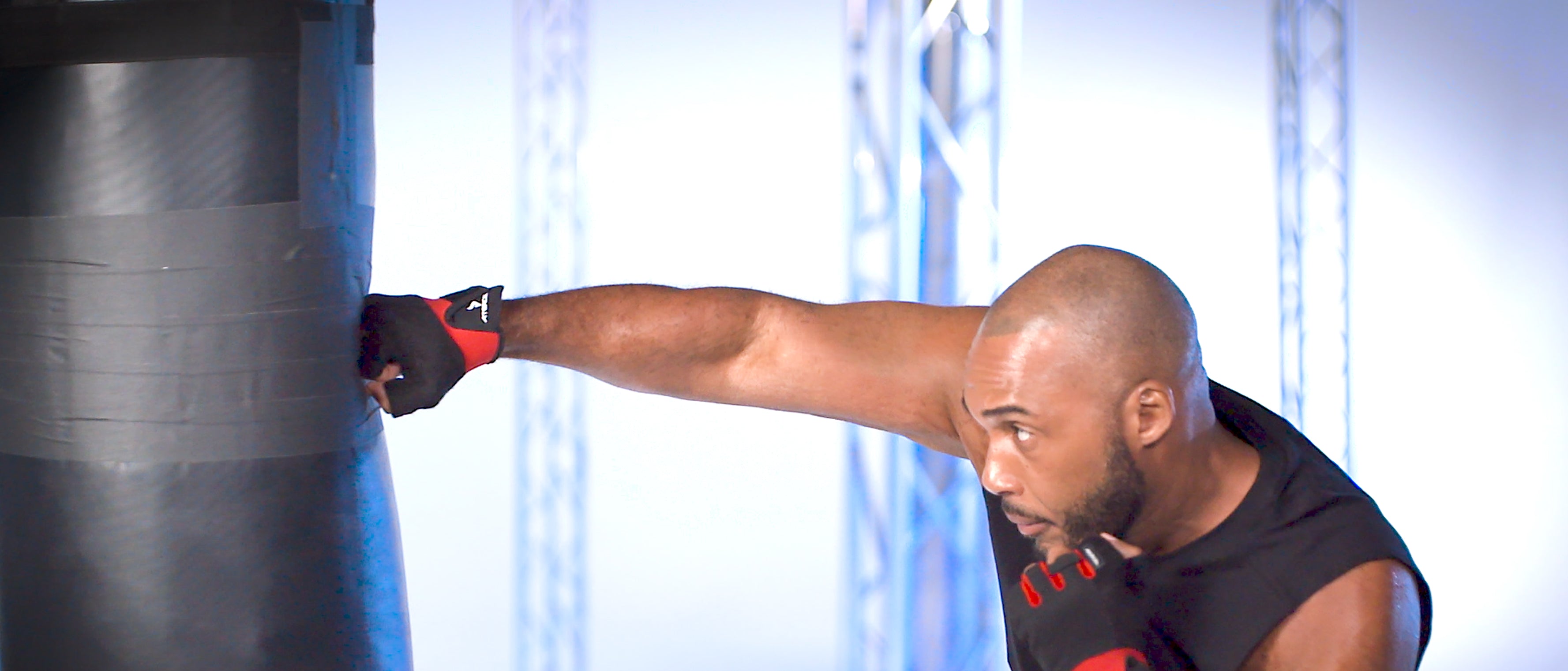 Person practicing boxing on a punching bag in a gym setting